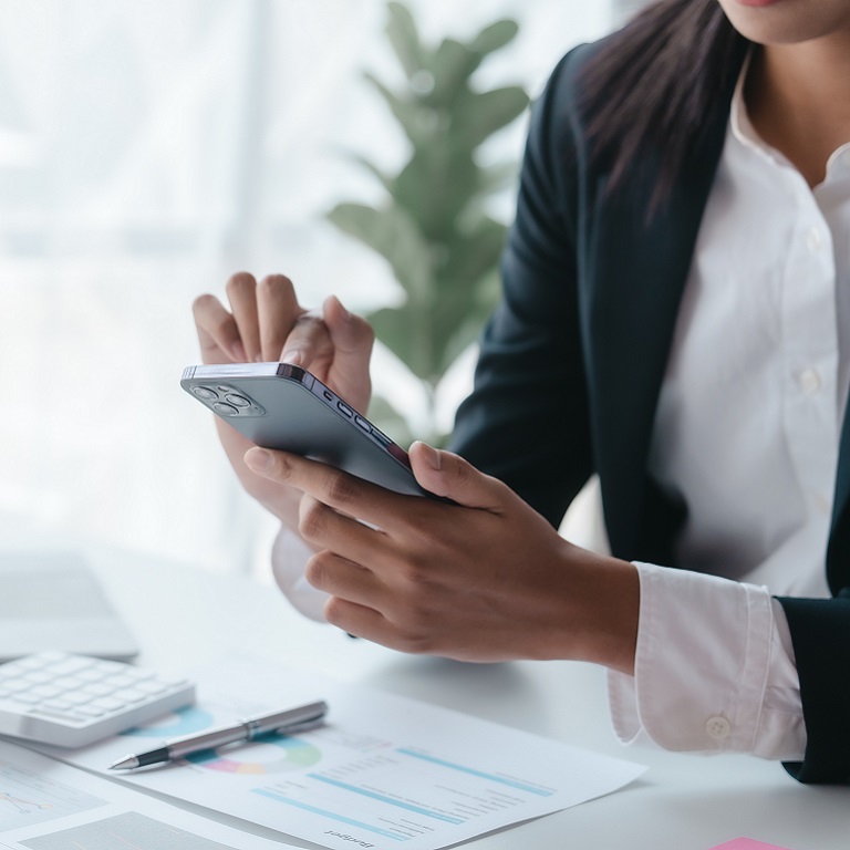Using mobile cellphone, Close up hands of asian bookkeeper female working with stack of papers and balance sheet with bureaucracy hardworking in office desk.